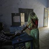 A woman shows voting slip before she casts her vote during the first round of voting of India&#x27;s national election in Behror, Rajasthan state, India, Friday, April 19, 2024. Nearly 970 million voters will elect 543 members for the lower house of Parliament for five years, during staggered elections that will run until June 1. (AP Photo/Manish Swarup)