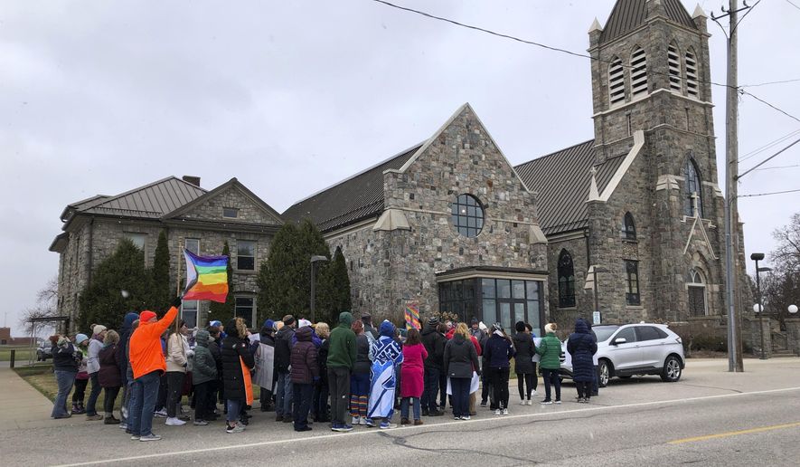 Protesters gather outside St. Joseph the Worker Church on March 17, 2024, in Beal City, Mich., in response to a priest&#x27;s criticism of a gay author who read a book at a parish school. The Rev. Thomas Held resigned as pastor on April 16, 2024. (Sue Knickerbocker Field/The Morning Sun via AP)