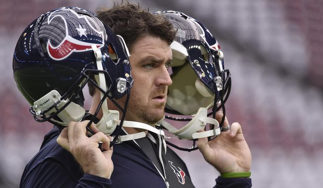 FILE - A Houston Texans staff member tests the helmet radio system before the first half of an AFC Wild Card NFL game between the Houston Texans and the Oakland Raiders, Saturday, Jan. 7, 2017, in Houston. Following a sign-stealing scandal that rocked the sport and hung over Michigan&#x27;s championship run in 2023, the NCAA&#x27;s football oversight committee approved Friday, April 19, 2024, the use of coach-to-player helmet communications in games for the 2024 season. The football rules committee last month made a recommendation to allow — but not require — teams at the highest tier of Division I to use radio technology similar to what NFL teams use. (AP Photo/Eric Christian Smith, File)