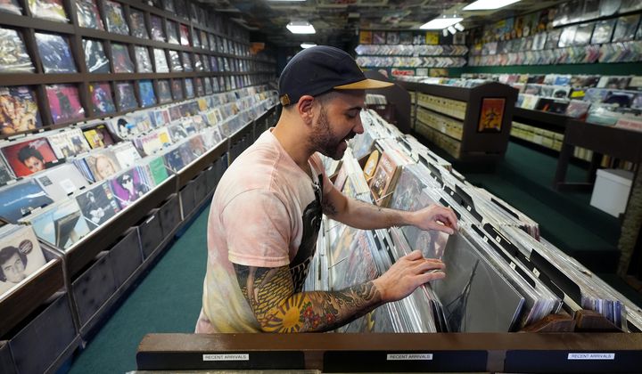 Jeff Maimon, of Chicago, checks out some vinyl at Tracks In Wax record shop, Thursday, April 18, 2024, in Phoenix. Special LP releases, live performances and at least one giant block party are scheduled around the U.S. Saturday as hundreds of shops celebrate Record Store Day amid a surge of interest in vinyl and the day after the release of Taylor Swift&#x27;s latest album. (AP Photo/Ross D. Franklin)