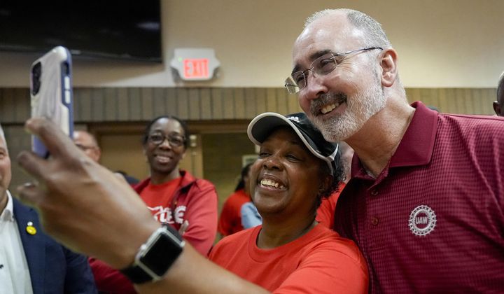 Volkswagen automobile plant employee LaShawn Hawthorne, center left, takes picture with UAW president Shawn Fain after workers voted to join the union Friday, April 19, 2024, in Chattanooga, Tenn. (AP Photo/George Walker IV) ** FILE **
