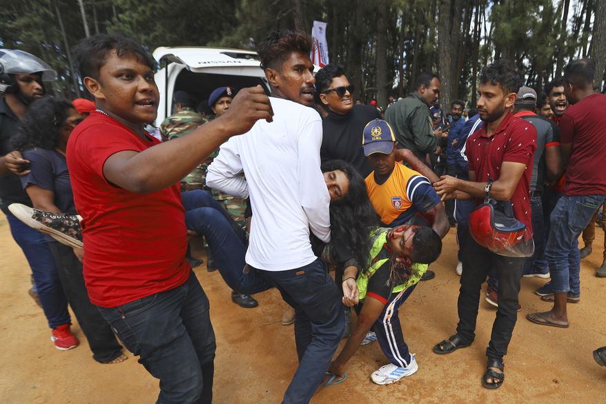People attend to the injured after a racing car crashed into the spectators during the Fox Hill Supercross, a motor racing event organized by the Sri Lanka's army, in Diyatalawa, Sri Lanka, Sunday, April 21, 2024. (AP Photo/STR)