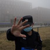 A security person moves journalists away from the Wuhan Institute of Virology after a World Health Organization team arrived for a field visit in Wuhan in China&#x27;s Hubei province on Feb. 3, 2021. The hunt for COVID-19 origins has gone dark in China. An AP investigation drawing on thousands of pages of undisclosed emails and documents and dozens of interviews found feuding officials and fear of blame ended meaningful Chinese and international efforts to trace the virus almost as soon as they began, despite years of public statements to the contrary. (AP Photo/Ng Han Guan, File)