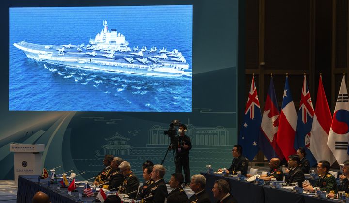 A screen shows a Chinese aircraft carrier at the opening of the Western Pacific Navy Symposium in Qingdao, eastern China&#x27;s Shandong province on Monday, April 22, 2024. Zhang Youxia, one of China&#x27;s top military leaders took a harsh line on regional territorial disputes, telling an international naval gathering in northeastern China on Monday that the country would strike back with force if its interests came under threat. (AP Photo/Ng Han Guan)