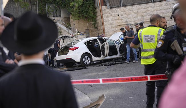 Israeli police investigate the scene of a suspected ramming attack that wounded three people on the eve of the Jewish holiday of Passover, in Jerusalem, Monday, April 22, 2024. Israeli police say a car slammed into pedestrians in Jerusalem on Monday, wounding three people lightly in an apparent attack.(AP Photo/Ohad Zwigenberg)