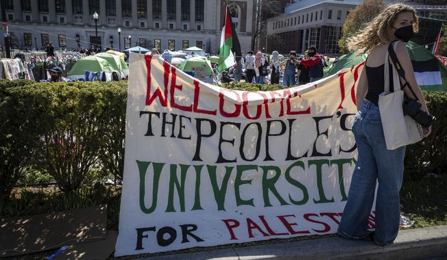A sign is displayed in front of the tents erected at the Pro-Palestine protest encampment at the Columbia University campus in New York on Monday April 22, 2024. (AP Photo/Stefan Jeremiah)