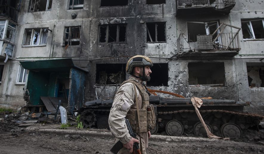 A Ukrainian soldier passes by a damaged apartment building in Chasiv Yar, the site of heavy battles with the Russian forces in the Donetsk region, Ukraine, Tuesday, May 9, 2023. (Iryna Rybakova via AP, File)
