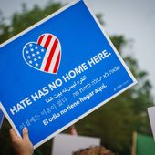 An activist in DC holds a protest sign that says &quot;Hate has no home here&quot; at the Unite the Right 2 counter-protest. WASHINGTON, DC - AUGUST 13, 2018. File photo credit: Stephanie Kenner via Shutterstock.