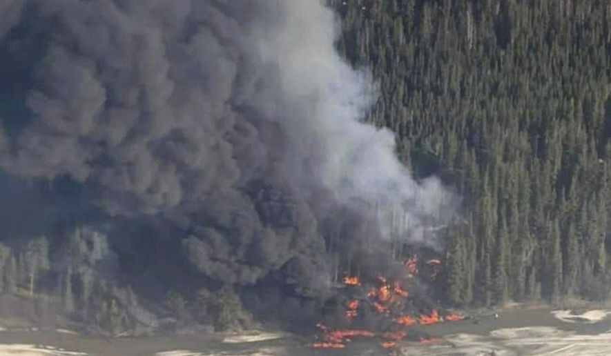 A fire burns after a Douglas C-54 Skymaster crashed into the Tanana River outside Fairbanks, Alaska, Tuesday, April 23, 2024. (Michaela Matherne via AP)