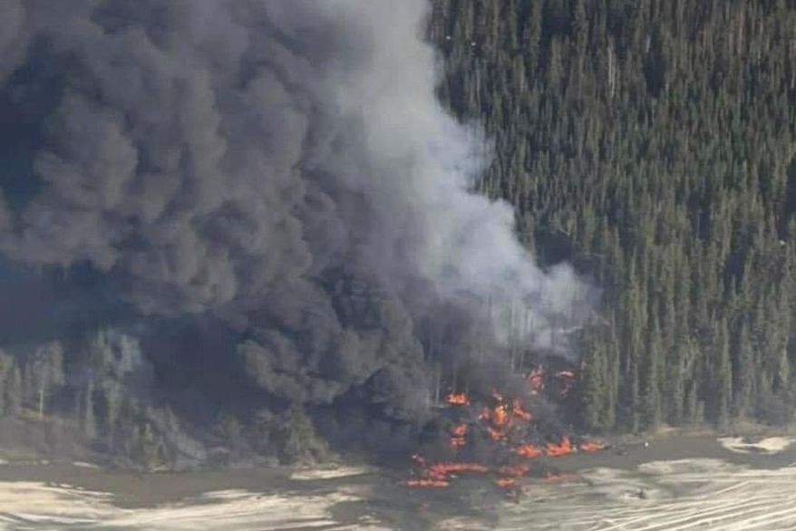 A fire burns after a Douglas C-54 Skymaster crashed into the Tanana River outside Fairbanks, Alaska, Tuesday, April 23, 2024. (Michaela Matherne via AP)
