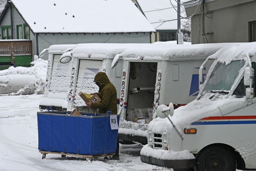 A mail carrier loads a mail truck with mail, March 1, 2024, in Lake Tahoe, Calif. The USPS announced on Tuesday, April 23, that it will follow through with its plan to reroute Reno-area mail processing to Sacramento, a move that drew bipartisan ire from Nevada lawmakers while raising questions about the rate at which mail ballots can be processed in a populous part of a crucial swing state. (AP Photo/Andy Barron, File)