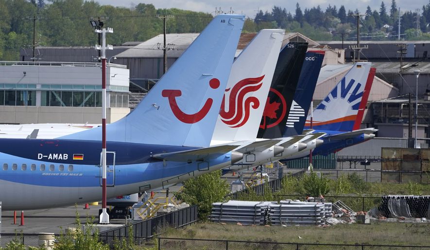 Boeing 737 Max airplanes, including one belonging to TUI Group, left, sit parked at a storage lot, Monday, April 26, 2021, near Boeing Field in Seattle. Boeing reports earnings on Wednesday, April 24, 2024. (AP Photo/Ted S. Warren, File)