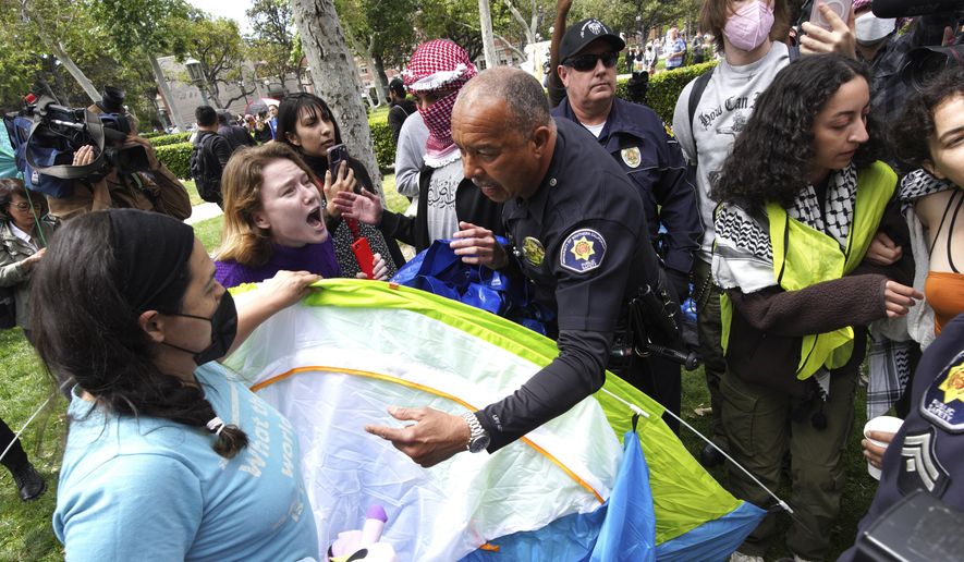 University of Southern California protesters fight with University Public Safety officers as they try to remove tents at the campus&#x27; Alumni Park during a pro-Palestinian occupation on Wednesday, April 24, 2024 in Los Angeles. (AP Photo/Richard Vogel)