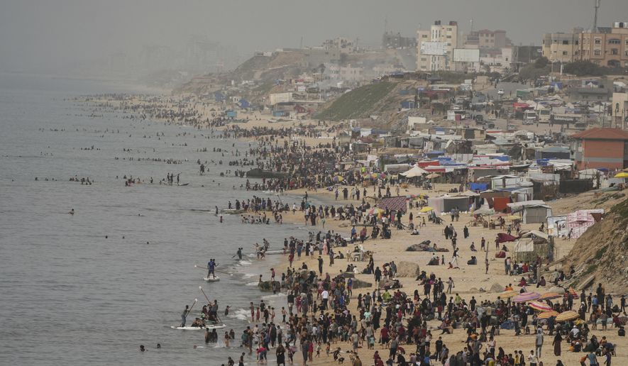Palestinians spend the day on the beach along the Mediterranean Sea during a heatwave in Deir al Balah, Gaza Strip, Thursday, April 25, 2024. Over 80% of Gaza&#x27;s population has been displaced by the ongoing war with Israel, and many have relocated to the area. Temperatures hovered near 37 degrees Celsius (100 degrees Fahrenheit). (AP Photo/Abdel Kareem Hana)