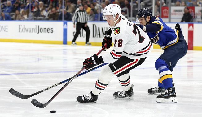 Chicago Blackhawks&#x27; Alex Vlasic (72) and St. Louis Blues&#x27; Alexey Toropchenko (13) vie for control of the puck during the second period of an NHL hockey game Wednesday, April 10, 2024, in St. Louis. (AP Photo/Scott Kane)