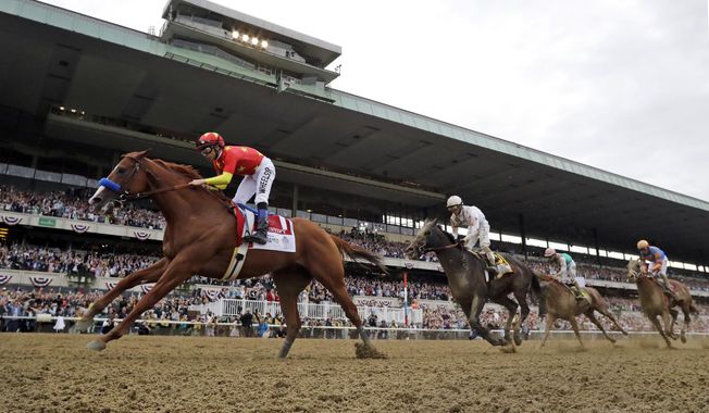 Justify (1), with jockey Mike Smith up, crosses the finish line to win the 150th running of the Belmont Stakes horse race, Saturday, June 9, 2018, in Elmont, N.Y. Triple Crown winner Justify, 2017 Horse of the Year Gun Runner and jockey Joel Rosario have been elected to the National Museum of Racing and Hall of Fame in their first year of eligibility. (AP Photo/Julio Cortez, File)