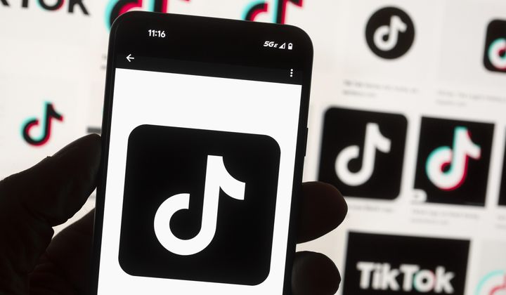 The TikTok logo is displayed on a mobile phone in front of a computer screen, Oct. 14, 2022, in Boston. (AP Photo/Michael Dwyer, File)