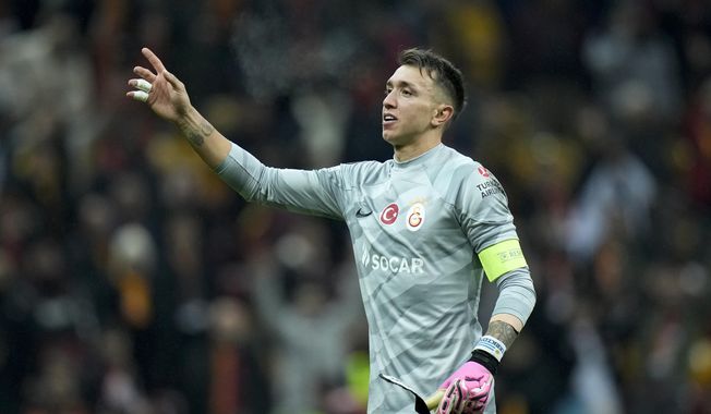 Galatasaray&#x27;s goalkeeper Fernando Muslera celebrates with supporters at the end of the Europa League play-off first league soccer match against Sparta Praha, in Istanbul, Turkey, Feb. 15, 2024. Muslera, who played in the past four World Cups, announced his retirement from international soccer on Thursday, April 25, 2024. (AP Photo/Francisco Seco)