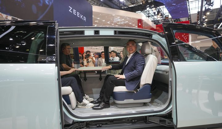 Visitors sit inside a Zeekr Mix car during the China Auto Show in Beijing, China, Friday, April 26, 2024. China&#x27;s vision of the future of the automobile electrified and digitally connected is on display at the ongoing Beijing auto show. (AP Photo/Tatan Syuflana)