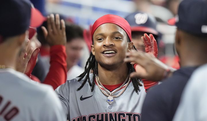 Washington Nationals&#x27; CJ Abrams is congratulated by teammates after he and Trey Lipscomb scored on a single by Joey Meneses during the eighth inning of a baseball game against the Miami Marlins, Friday, April 26, 2024, in Miami. (AP Photo/Wilfredo Lee)