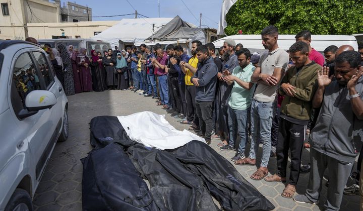 Mourners pray over the bodies of Palestinians who were killed in an Israeli airstrike in Nuseirat, at the Al Aqsa hospital in Deir al Balah, Gaza Strip, Saturday, April 27, 2024. (AP Photo/Abdel Kareem Hana)
