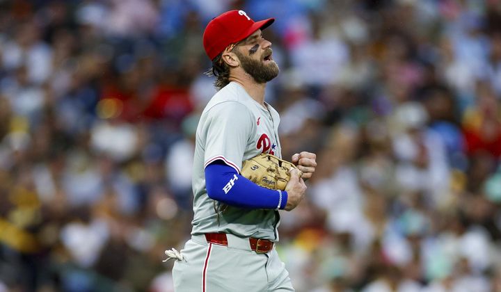 Philadelphia Phillies first basemen Bryce Harper reacts after a collision at first with San Diego Padres&#x27; Jurickson Profar during the second inning of a baseball game, Friday, April 26, 2024, in San Diego. (AP Photo/Brandon Sloter)