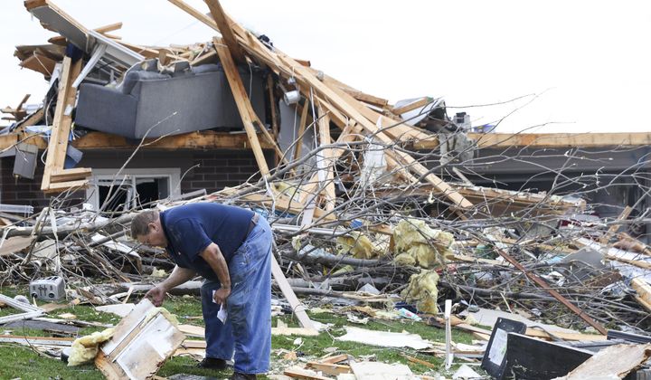 Terry Kicking sifts through the damage after a tornado leveled his home, Friday, April 26, 2024, in Omaha, Neb. (Nikos Frazier/Omaha World-Herald via AP)