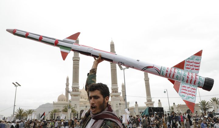 A Houthi supporter raises a mock rocket during a rally against the U.S. and Israel and to support Palestinians in the Gaza Strip, in Sanaa, Yemen, Friday, April. 26, 2024. (AP Photo/Osamah Abdulrahman)
