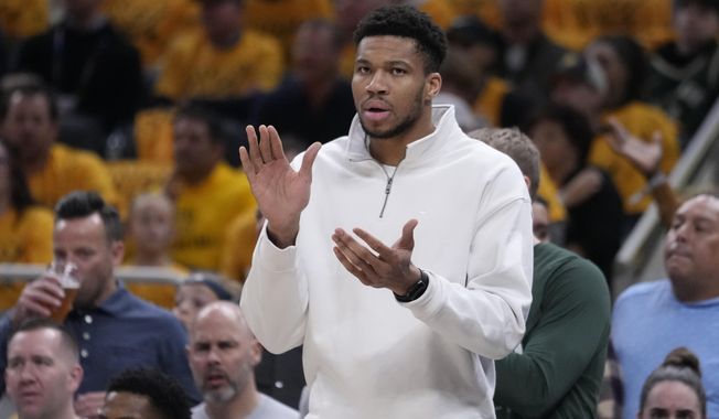 Milwaukee Bucks forward Giannis Antetokounmpo cheers from the bench during the first half in Game 2 against the Indiana Pacers in an NBA basketball first-round playoff series, Friday, April 26, 2024, in Indianapolis. (AP Photo/Michael Conroy)