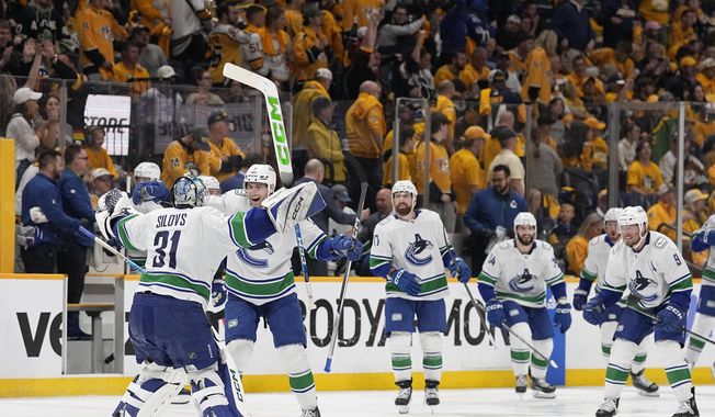 Vancouver Canucks goaltender Arturs Silovs (31) and defenseman Carson Soucy (7) celebrate the team&#x27;s 4-3 overtime win against the Nashville Predators in Game 4 of an NHL hockey Stanley Cup first-round playoff series Sunday, April 28, 2024, in Nashville, Tenn. (AP Photo/George Walker IV)