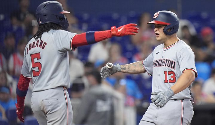 Washington Nationals&#x27; CJ Abrams (5) congratulates Nick Senzel (13) after Senzel hit a home run scoring Abrams during the fourth inning of a baseball game against the Miami Marlins, Sunday, April 28, 2024, in Miami. (AP Photo/Wilfredo Lee)