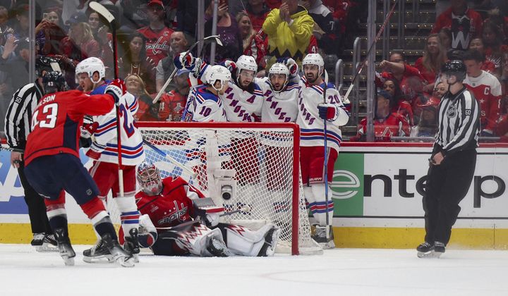 New York Rangers players celebrate after scoring against the Washington Capitals during the first period in Game 4 of an NHL hockey Stanley Cup first-round playoff series, Sunday April 28, 2024, in Washington. (AP Photo/Tom Brenner)