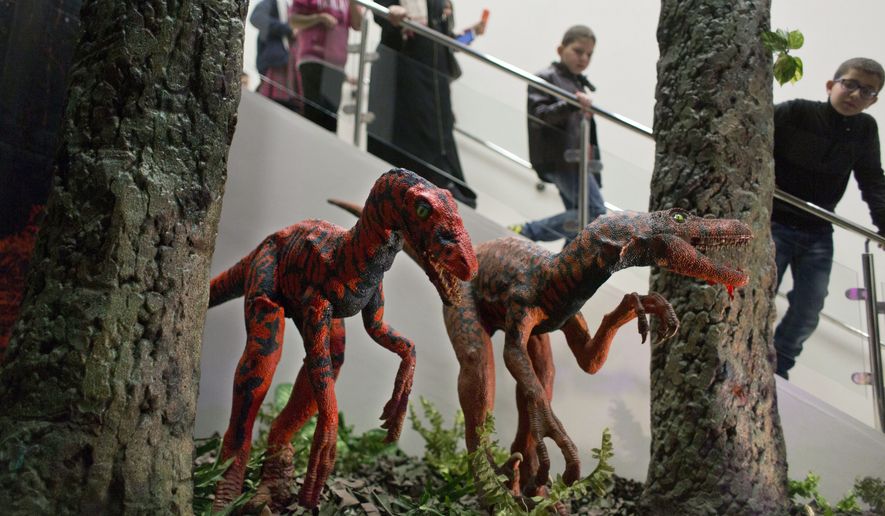 Visitors look at models of the Velociraptor Dinosaurs during the opening ceremony of the Baby Dinosaurs and Giant Insect Exhibition, in the West Bank city of Bethlehem, Tuesday, March 14, 2017. The exhibition was donated by the Bethlehem-Bath Links charity, based in the British city of Bath, in an effort to help create the first Palestinian children's natural history museum. (AP Photo/Nasser Nasser) **FILE**