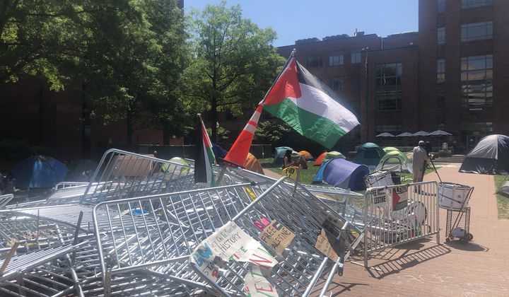 Demonstrators at George Washington University broke down a metal barrier early Monday that cordoned off the encampment. Activists have since planted a Palestinian flag in the middle of the heap. (Matt Delaney/The Washington Times)