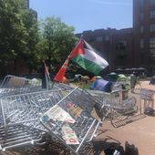 Demonstrators at George Washington University broke down a metal barrier early Monday that cordoned off the encampment. Activists have since planted a Palestinian flag in the middle of the heap. (Matt Delaney/The Washington Times)
