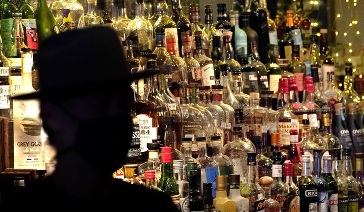 Bottles of alcohol sit on shelves at a bar in Houston on June 23, 2020. Moderate drinking was once thought to have benefits for the heart, but better research methods starting in the 2010s have thrown cold water on that. (AP Photo/David J. Phillip) **FILE**