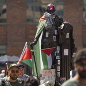 Stickers and Palestininan flags cover a statue of George Washington at an encampment by students protesting against the Israel-Hamas war at George Washington University on Tuesday, April 30, 2024, in Washington. (AP Photo/Mark Schiefelbein)