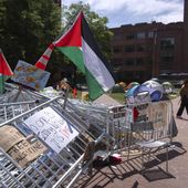 A person walks past a pile of barricades at an encampment by students protesting against the Israel-Hamas war at George Washington University on Tuesday, April 30, 2024, in Washington. (AP Photo/Mark Schiefelbein)