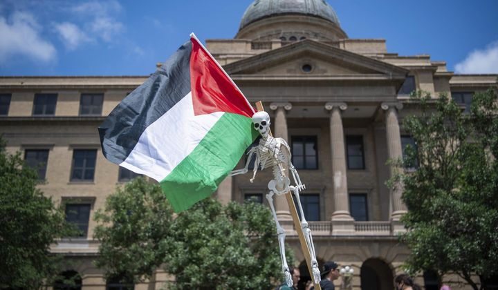 A Palestinian flag and skeleton hang in front of the Texas A&amp;M Academic Building on campus Monday, April 29, 2024, in College Station, Texas. (Meredith Seaver/College Station Eagle via AP)