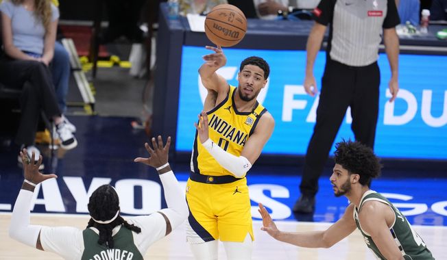 Indiana Pacers&#x27; Tyrese Haliburton (0) makes a pass against Milwaukee Bucks&#x27; Jae Crowder (99) and Andre Jackson Jr. during the second half of Game 4 of the first round NBA playoff basketball series, Sunday, April 28, 2024, in Indianapolis. (AP Photo/Michael Conroy) **FILE**