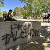 Students walk by one of the spray-painted messages left by those protesting the Israel-Hamas war on the University of New Mexico campus in Albuquerque, New Mexico, Wednesday, May 1, 2024. Sixteen people, including five students, were arrested earlier this week when they occupied the Student Union Building, causing damage inside. (AP Photo/Susan Montoya Bryan)