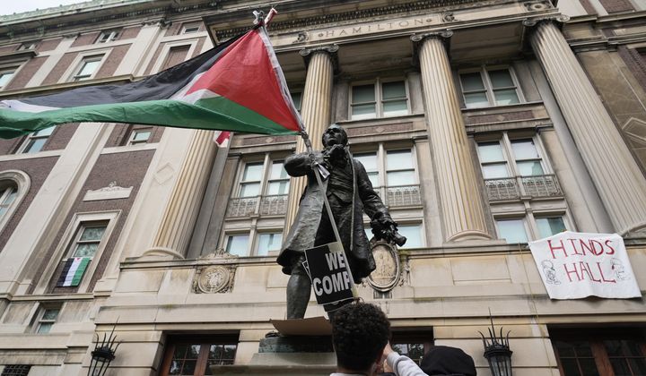 A student protester parades a Palestinian flag outside the entrance to Hamilton Hall on the campus of Columbia University, Tuesday, April 30, 2024, in New York. (AP Photo/Mary Altaffer, Pool, File)
