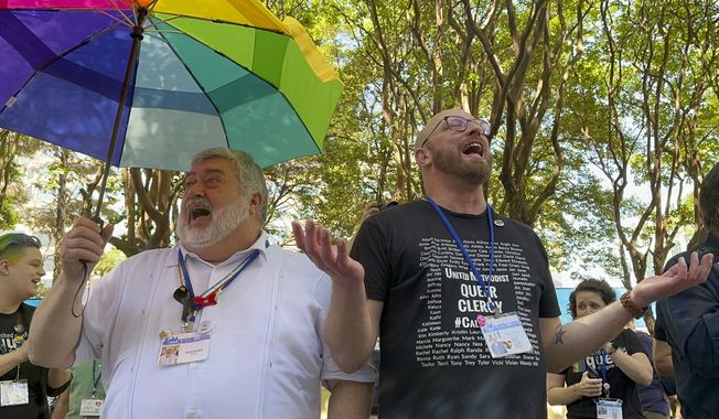 The Rev. David Meredith, left, and the Rev. Austin Adkinson sing during a gathering of those in the LGBTQ community and their allies outside the Charlotte Convention Center, in Charlotte, N.C., Thursday, May 2, 2024. They were celebrating after the General Conference of the United Methodist Church voted to remove the denomination&#x27;s 52-year-old social teaching that deemed homosexuality &quot;incompatible with Christian teaching.&quot; (AP Photo/Peter Smith)
