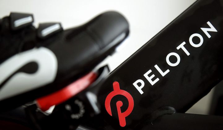 This Nov. 19, 2019, file photo shows the logo on a Peloton bike in San Francisco. Peloton is cutting about 400 jobs worldwide as part of a restructuring effort and its CEO Barry McCarthy is stepping down after two years as the company continues to work on turning around its business. Peloton Interactive Inc. said Thursday, May 2, 2024, that the job reductions amount to approximately 15% of its global headcount. (AP Photo/Jeff Chiu, File)