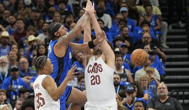Orlando Magic forward Paolo Banchero loses the ball as he gets caught between Cleveland Cavaliers forward Isaac Okoro, left, and forward Georges Niang (20) during the first half of Game 6 of an NBA basketball first-round playoff series, Friday, May 3, 2024, in Orlando, Fla. (AP Photo/John Raoux)