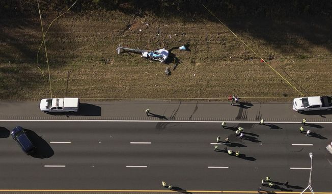In this image taken with a drone, emergency personnel work at the scene of a helicopter crash on the side of Interstate 77 South in Charlotte, N.C., Nov. 22, 2022. Investigators found disconnected and missing hardware aboard the helicopter that crashed in 2022, killing the pilot and a North Carolina television station’s meteorologist, according to the National Transportation Safety Board&#x27;s final report on the crash, which was released Thursday, May 2, 2024. (Alex Slitz/The Charlotte Observer via AP, File)