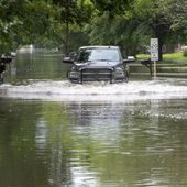 A pickup truck maneuvers a residential street filled with water in Woodloch, Texas, subdivision near The Woodlands as floodwaters rise Friday, May 3, 2024. Torrential rain is inundating southeastern Texas, forcing schools to cancel classes and closing numerous highways around Houston. (Kirk Sides/Houston Chronicle via AP)