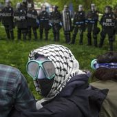 A pro-Palestinian demonstrator wears goggles and a mask as police with riot shields and protesters stand across from one another on the grounds of the University of Virginia, in Charlottesville, Va., where tents are set up, Saturday, May 4, 2024. (Cal Cary/The Daily Progress via AP)