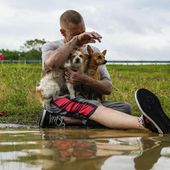 Tim McCanon sits on the road with his dogs after being rescued by the Community Fire Department during severe flooding on Friday, May 3, 2024, in New Caney, Texas. (Raquel Natalicchio/Houston Chronicle via AP)