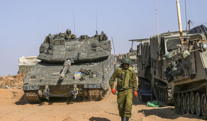 Israeli soldiers drive a tank at a staging ground near the border with the Gaza Strip, in southern Israel, Sunday, May 5, 2024. (AP Photo/Tsafrir Abayov)